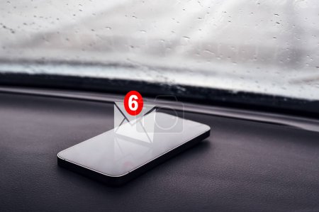 Téléchargez les photos : Icône de notification par SMS sur smartphone en voiture, mise au point sélective - en image libre de droit
