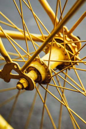 Foto de Rueda de bicicleta vieja pintada en color amarillo vibrante, enfoque selectivo - Imagen libre de derechos
