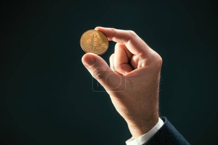 Téléchargez les photos : Crypto-monnaie commerçant tenant Bitcoin pièce dans la main, foyer sélectif - en image libre de droit