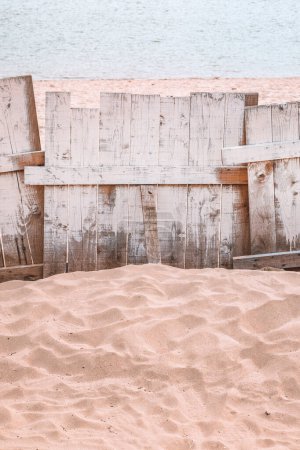 Téléchargez les photos : Clôture en bois sur la plage de sable du Danube, image verticale avec mise au point sélective - en image libre de droit