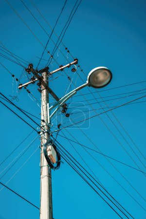 Téléchargez les photos : Réverbère avec poteau électrique et fils électriques désordonnés, vue à angle bas - en image libre de droit