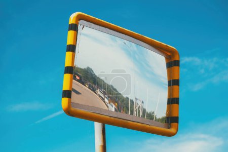 Old traffic mirror with yellow plastic frame, selective focus