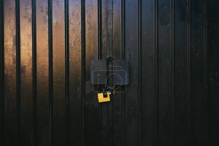 Téléchargez les photos : Porte de garage noire avec cadenas comme arrière-plan - en image libre de droit