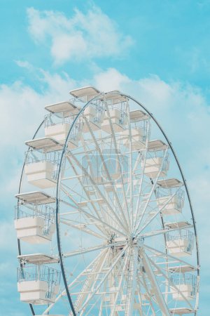 Téléchargez les photos : Grande roue pour vue panoramique dans le parc d'attractions est populaire divertissant tour, tourné contre le ciel d'été par une journée ensoleillée, foyer sélectif - en image libre de droit