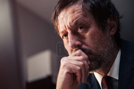 Photo for Businessman rethinking, headshot portrait of mid adult male entrepreneur thinking with hand on the chin, selective focus - Royalty Free Image