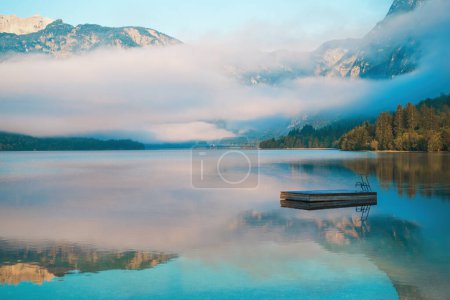 Small floating pier on lake Bohinj surface in summer morning, selective focus