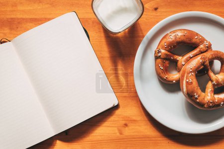 Téléchargez les photos : Bretzels et yaourts pour le petit déjeuner, nourriture et carnet vierge sur la table, vue sur le dessus - en image libre de droit