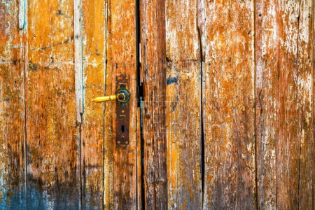 Antigua puerta de entrada de madera desgastada con pintura en escamas como textura grunge y fondo