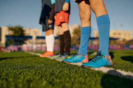 Photo for Closeup leg of teenage football player on white line across green soccer lawn with artificial grass - Royalty Free Image