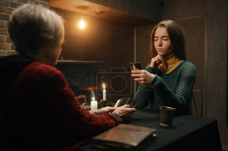 Photo for Serious concentrated woman looking at divination tarot card at soothsayer personal consultation therapeutically spiritual session - Royalty Free Image