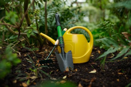Téléchargez les photos : Watering can, shovel and rake garden tool closeup selective focus. Gardening, farming hobby concept - en image libre de droit