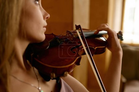 Téléchargez les photos : Beautiful young woman playing violin. Closeup romantic female musician performance - en image libre de droit