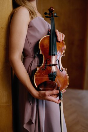 Photo for Violin in female hands. Elegant woman musician holding classic musical instrument. Cropped shot - Royalty Free Image