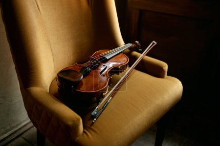 Photo for Violin musical instrument on the chair. Violinist equipment for music performance - Royalty Free Image
