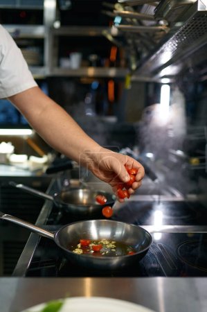 Photo for Master chef preparing tomato sauce for pasta in frying pan. Cooking steps process on professional kitchen - Royalty Free Image