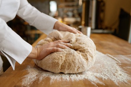Foto de Proceso de cocción. Primer plano panadero manos amasando masa en la mesa. Preparación de pasteles ecológicamente naturales - Imagen libre de derechos