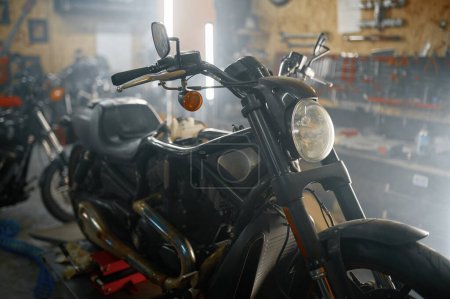 Foto de Moto de pie en servicio en el taller de garaje creativo auténtico. Concepto de diagnóstico, mantenimiento y reparación de motocicletas - Imagen libre de derechos