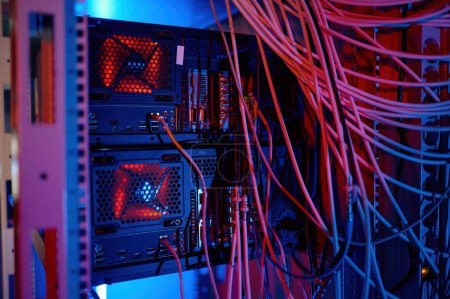 Foto de Panel de red, conmutador y cable en centro de datos con tono de luz de neón. Primer plano de los equipos de telecomunicaciones - Imagen libre de derechos