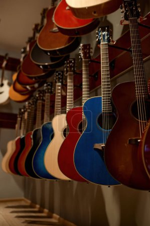 Photo for Selective focus on rack of acoustic guitar string instrument hanging on wall at music shop store. Market sale - Royalty Free Image