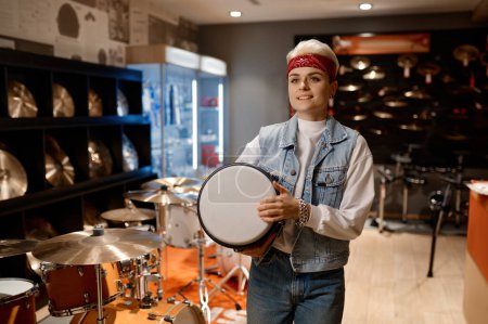 Photo for Young hipster woman choosing drum unit at musical shop store feeling satisfaction and happiness - Royalty Free Image