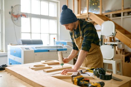 Foto de Hombre carpintero aplicando pegamento a bordo de maderas de madera antes de instalar - Imagen libre de derechos
