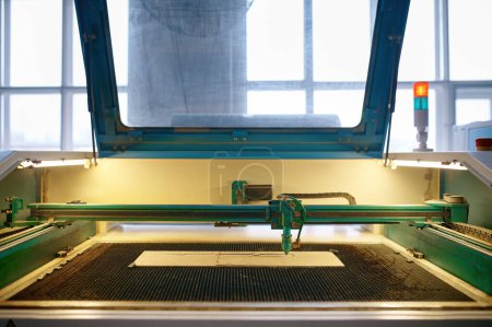 Foto de Una máquina láser CNC automatizada que funciona con tablón de madera. Proceso de carpintería, corte y grabado - Imagen libre de derechos