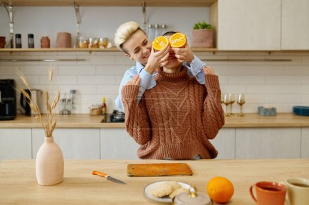 Téléchargez les photos : Heureux couple LGBTQ amoureux de femmes qui s'amusent tout en préparant le dîner végétarien à la maison cuisine - en image libre de droit