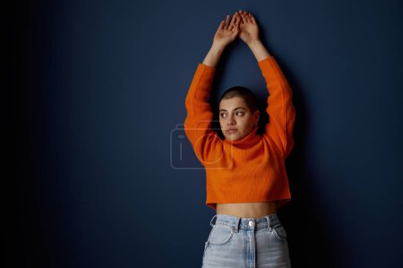 Foto de Retrato de joven atractiva mujer lesbiana hipster sobre fondo azul oscuro. Autoaceptación, orientación sexual no tradicional y concepto de comunidad lgbt - Imagen libre de derechos