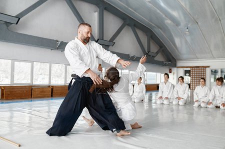 Foto de Aikido sensei y adolescente estudiante de formación lanzando y cayendo. Concepto de práctica de artes marciales - Imagen libre de derechos