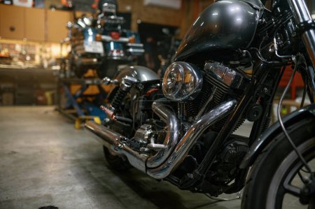 Téléchargez les photos : Moto personnalisée brillante après réparation et restauration dans un atelier professionnel. Véhicule en attente pour propriétaire de vélo - en image libre de droit