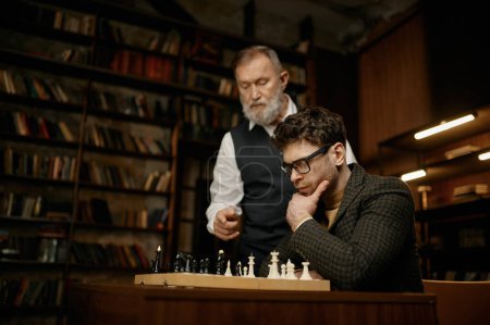 Photo for Pensive young man looking at chess board and listening hints older father. Senior parent teaching son playing strategic game at home library. Weekend intelligent activity concept - Royalty Free Image