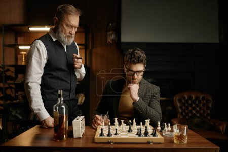 Photo for Two chess players taking break for smoking cigars and planning strategy of game. - Royalty Free Image
