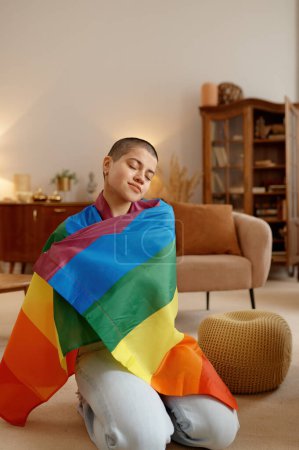 Foto de Mujer joven lgbt envuelta en la bandera del arco iris sentirse orgullosa de su orientación sexual. Concepto de autoaceptación - Imagen libre de derechos