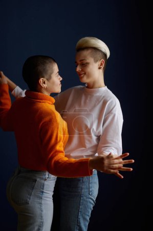 Foto de Felizmente sonriente mujer lesbiana pareja bailando juguetonamente juntos sintiendo amor y alegría. Concepto de romance y relación homosexual - Imagen libre de derechos