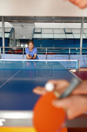 Foto de Mujer adulta vestida con ropa deportiva jugando al tenis de mesa en el gimnasio. Clase de entrenamiento en el club de juego de ping pong - Imagen libre de derechos