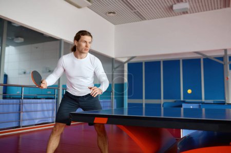 Photo for Portrait of young table tennis player training in sport club. Hipster guy enjoying ping pong game practicing technique - Royalty Free Image
