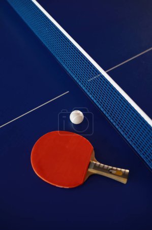 Foto de Equipo de tenis de mesa en mesa de ping pong azul con rejilla. Club deportivo y clase de entrenamiento para la mejora de habilidades. Tenis naturaleza muerta - Imagen libre de derechos