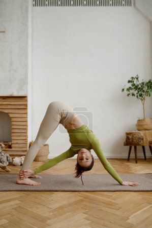 Photo for Young woman doing yoga stretching exercise on the floor. Wellbeing and healthy sport lifestyle concept - Royalty Free Image