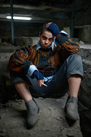 Téléchargez les photos : Portrait d'adolescente déprimée mendiante se sentant déçue assise et fumant - en image libre de droit