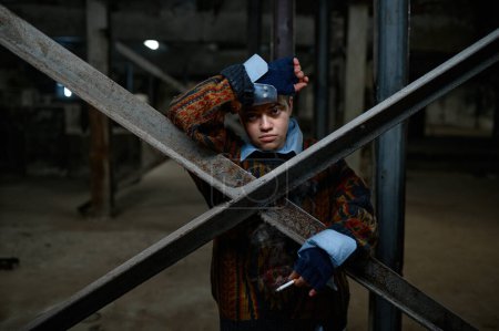 Foto de Retrato de una adolescente hipster refugiada o mendiga con cigarrillo en un edificio abandonado. Persona sin hogar deprimida - Imagen libre de derechos