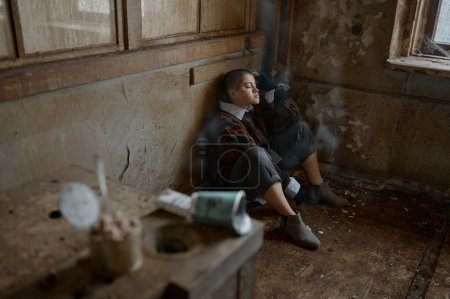 Foto de Enfoque selectivo de la mujer sin esperanza mendigo durmiendo en la esquina de la habitación. Concepto de pobreza, depresión y soledad - Imagen libre de derechos
