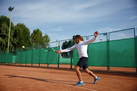 Téléchargez les photos : Joueur de tennis professionnel avec raquette jouant sur un terrain dur extérieur. Activité sportive de plein air entraînement sportif - en image libre de droit
