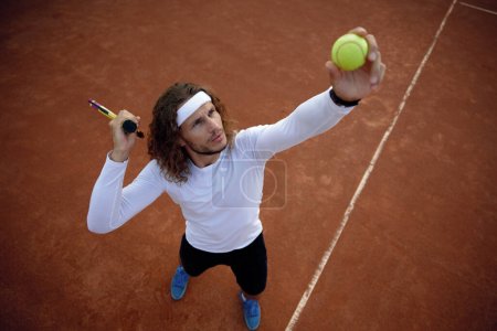 Foto de Vista de ángel alto en el jugador de tenis hombre sirviendo pelota. Deportista listo para golpear la volea disfrutando de un interesante partido de juego - Imagen libre de derechos