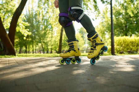 Photo for Closeup boy legs wearing roller skates over green nature of urban park background. Happy active recreation time and training exercise on rollerblades outdoors - Royalty Free Image