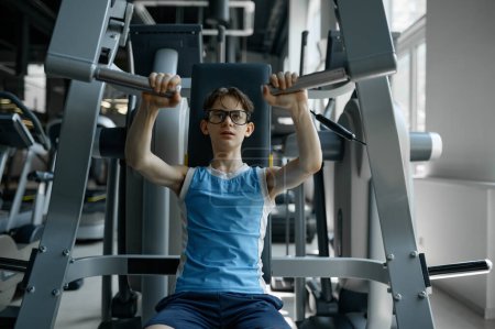 Photo for Boy nerd exercising using professional sports gym equipment. Keeping body fit concept - Royalty Free Image