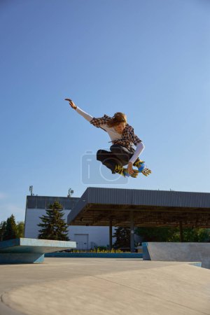 Photo for Roller skating concept, young male skater jumping high on ramp. Teenager boy enjoying speed rollerblading in park - Royalty Free Image