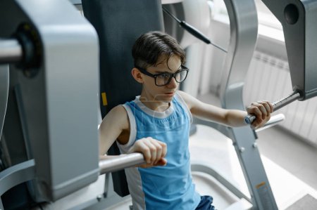 Téléchargez les photos : Skinny preteen nerd essayer d'être forte et saine formation avec des équipements de gymnastique sportive pour la santé et la puissance - en image libre de droit