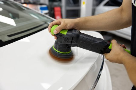 Photo for Professional worker applying special polishing paste and tool for car painting coat refreshment. Closeup view - Royalty Free Image