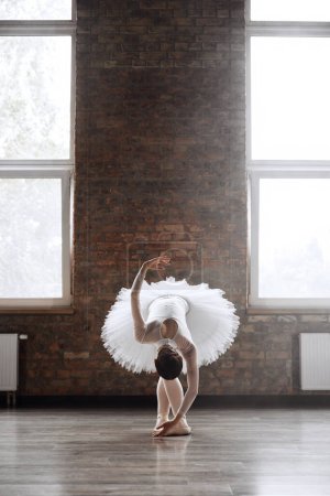 Foto de Bailarina de ballet clásica haciendo roll down al final de su actuación. Mujer elegante estudiante de la escuela de baile profesional - Imagen libre de derechos
