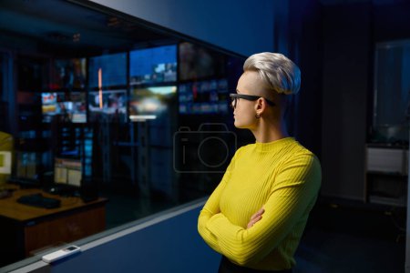 Photo for Portrait of young and successful female media center worker standing in dark studio room - Royalty Free Image